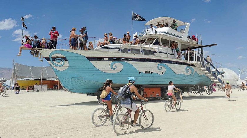 An old wooden yacht art car rolls through the playa at Burning Man on the Black Rock Desert near Gerlach, Nev. on Friday Aug. 31, 2012 on Friday Aug. 31, 2012. (AP Photo/Reno Gazette-Journal, Andy Barron)