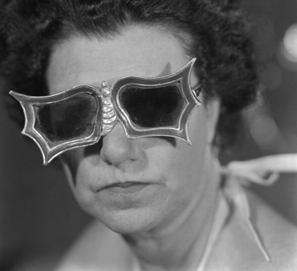 Peggy-Guggenheim-con-gli-occhiali-a-forma-di-farfalla-creati-per-lei-da-Edward-Melcarth-1949
